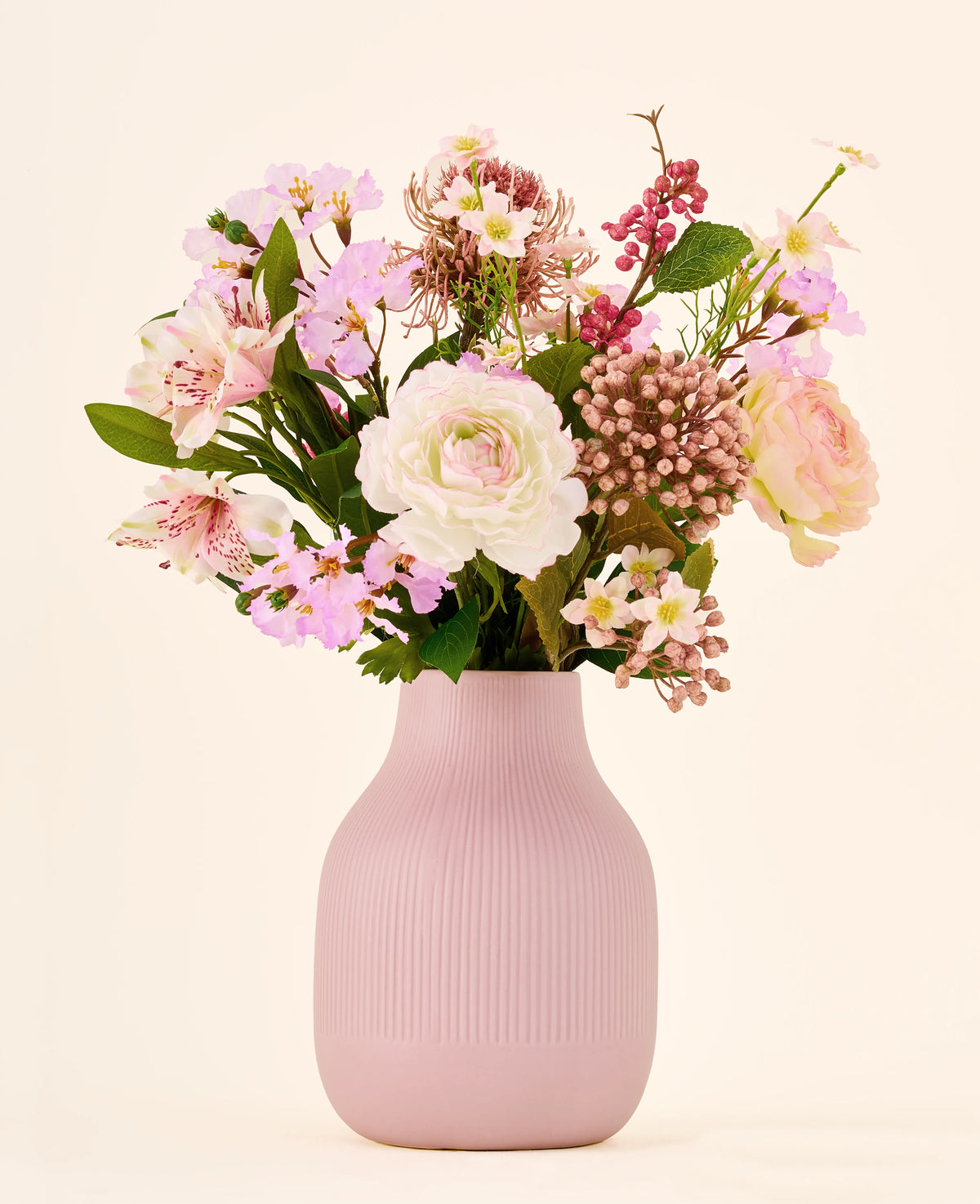 Zijden kunstbloemenboeket Boho Blossom, bestaande uit roze en witte zijden kunstbloemen, geschikt in een geribbelde, lichtroze vaas.