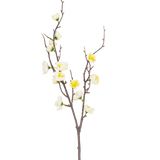 De Kunsttak Prunus 78 cm wit heeft een enkele bruine tak met meerdere uitlopers, versierd met kleine witte en gele bloemen, tegen een effen witte achtergrond.