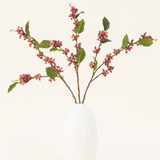 Zijden kunstbloemenboeket Berries Roze met groene bladeren in een witte vaas, perfect voor een minimalistisch interieur.