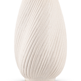 De Vaas Morning 25 cm beige is een vaas van gestructureerd, gebroken wit keramiek met een ronde vorm en diagonale golfachtige richels, tegen een effen witte achtergrond. Ideaal om zijden bloemen in te zetten.