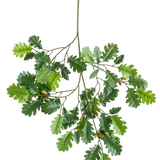 De Kunsttak Eikentak 67 cm FR heeft een tak met verschillende groene eikenbladeren en een paar eikels tegen een witte achtergrond.