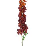 De Kunstbloem Delphinium 105 cm bordeaux heeft een lange, enkele steel met meerdere donkerrode en oranje kunstbloemen en groene bladeren, geïsoleerd afgebeeld op een witte achtergrond.