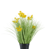 In een zwarte plastic pot staat de Kunstgras wortel bloemen uiengras, met lange, dunne, grasachtige bladeren en trossen kleine, felgele bloemen aan de uiteinden. De kunstplant is 50 cm hoog, brandvertragend en staat tegen een effen witte achtergrond.