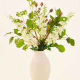 Zijden kunstbloemenboeket Pure Harmony, bestaande uit roze en witte bloemen met groene bladeren, geschikt in een geribbelde, crèmekleurige vaas.