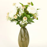 Een groene, geribbelde vaas van keramiek bevat het Zijden kunstbloemen boeket White Love - een arrangement van witte en crèmekleurige bloemen met groene bladeren tegen een effen lichte achtergrond.