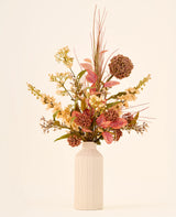 Een boeket van zijden kunstbloemen, Vintage Grace, samengesteld met onderhoudsvriendelijk kunstgroen in een hoge, gestructureerde, gebroken witte vaas.