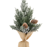 Kleine, compacte kunstkerstboom mini Solberg van 24 cm met besneeuwde takken en twee dennenappels, aan de voet omwikkeld met jute.