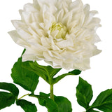 De Kunst Georgine Real Touch wit 70cm heeft een grote witte dahlia in volle bloei met gelaagde bloemblaadjes op een groene steel en bladeren, tegen een effen witte achtergrond.