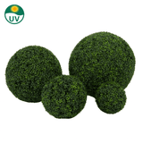 De Kunstplant Buxus romeinse stijl UV D40cm is afgebeeld op een witte achtergrond. Een cirkelvormig UV-icoon met een zon benadrukt de UV-bestendigheid, wat zorgt voor langdurig groen.