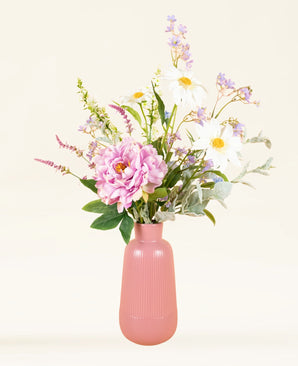 Een roze vaas toont het Zijden kunstbloemen boeket Misty Minthe, met witte margrieten, roze pioenrozen, paarse bloesems en eucalyptustakjes, tegen een lichte neutrale achtergrond.
