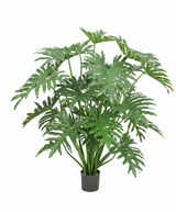 De Kunstplant Philodendron 125 cm heeft weelderige, glanzende, gespleten bladeren en is in pot afgebeeld tegen een effen witte achtergrond.