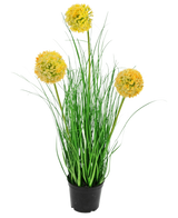 Een zwarte pot met hoge groene bladeren en drie gele pomponbloemen - deze Kunst Grasplant Ui 50 cm brandvertragend voegt een vrolijke, brandvertragende touch toe aan elke ruimte.