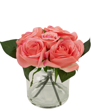 De Kunstrozenboeket Real Touch Roze 18cm heeft een kleine glazen vaas met levensechte roze rozen en groene bladeren, netjes gerangschikt om de stelen door het heldere glas te laten zien.